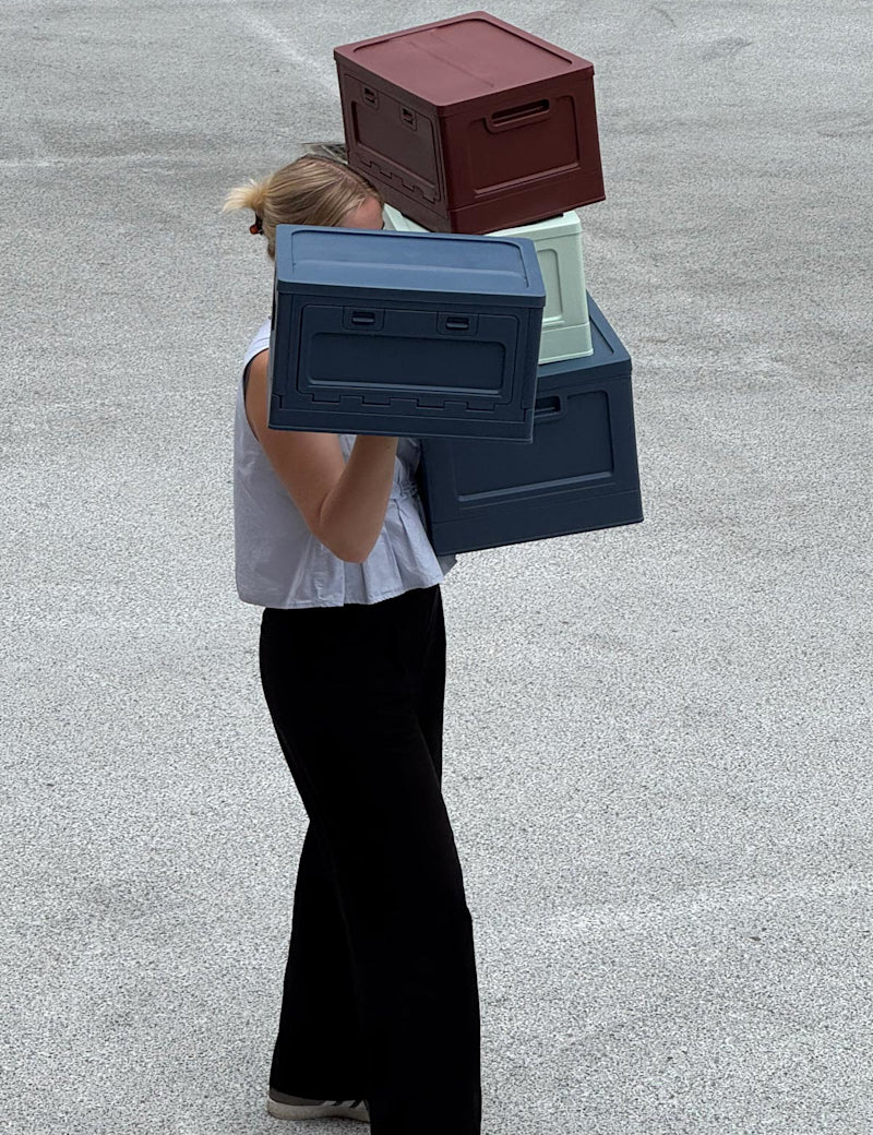 Studio About Moodbild Frau mit vielen Boxen auf den Armen