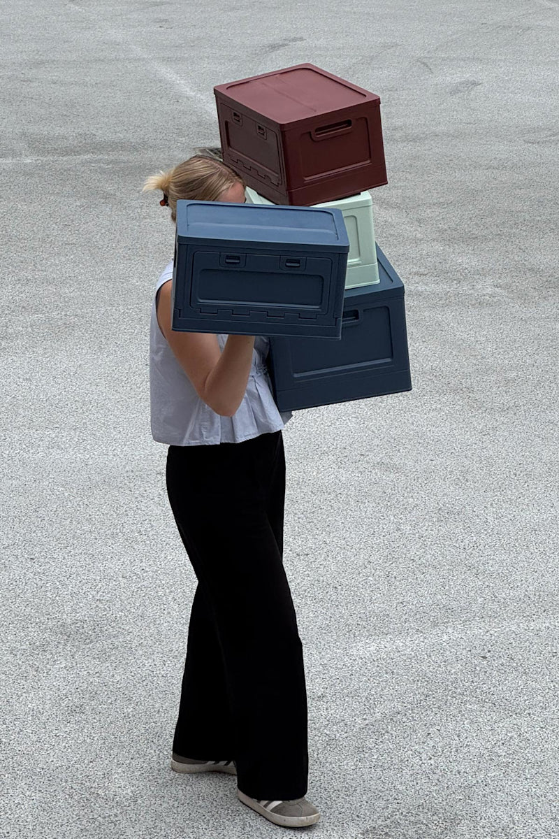 Studio About Moodbild Frau mit vielen Boxen auf den Armen